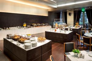un restaurante con una línea de buffet con comida en las mesas en Esperos Palace Luxury & Spa Hotel, en Kastoria