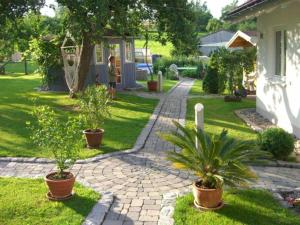 a garden with potted plants and a brick walkway at Haus Fechtig in Bonndorf im Schwarzwald
