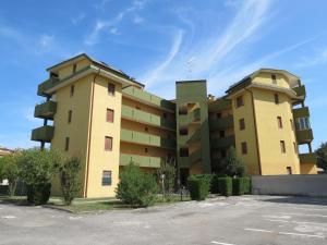 due edifici di appartamenti gialli con parcheggio di Mansarda Bilocale Vista Mare a Lido delle Nazioni