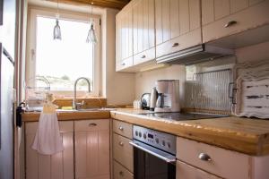 a kitchen with white cabinets and a sink with a dress on the counter at Oak & Pine in Palaios Agios Athanasios