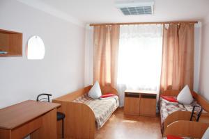 a room with two beds and a desk and a window at Vydubychi in Kyiv
