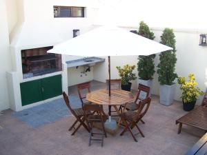 a table and chairs with an umbrella on a patio at Piccaluga Apartments in Buenos Aires