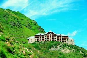 un gran edificio en la cima de una colina verde en Résidence Azureva La Mongie en La Mongie