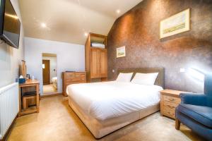 a bedroom with a white bed and a blue chair at The Red Lion in Cambridge