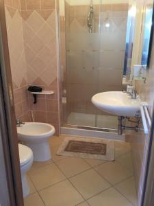 a bathroom with a toilet and a sink and a shower at La Rosa dei Venti in Villaputzu