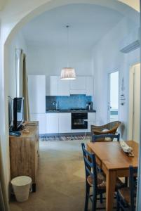 a living room with a table and a kitchen at Case Gallina in Avola