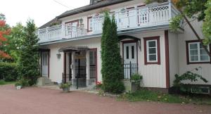 a white and red house with a balcony at Hotel Palo in Naantali