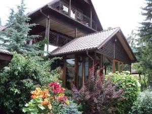 ドゥラウにあるCasa Serbanのバルコニー付きの大きな建物で、一部の植物を植えています。