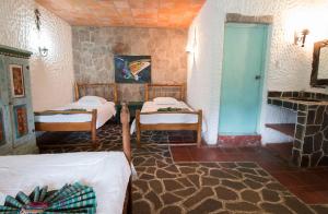 a bedroom with a bed and a desk at Eco Hotel Uxlabil Atitlan in San Juan La Laguna