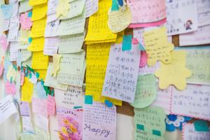 a wall covered in sticky notes and wishes at Elisa House in Ji'an