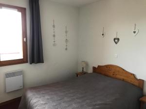 un dormitorio con una cama y una ventana en Le Corbier résidence Les Pistes, en Le Corbier