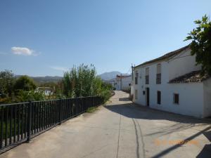 un vicolo con una recinzione accanto a un edificio bianco di Alojamiento rural El Batán a Priego de Córdoba