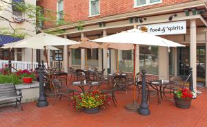 an outdoor patio with tables and chairs and umbrellas at Gettysburg Hotel in Gettysburg