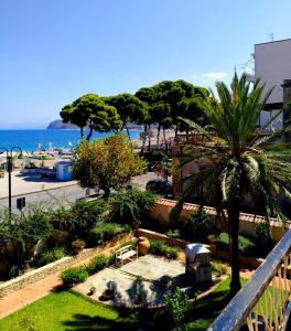 vista su un parco con palme e sull'oceano di Villa Chelia a Patti