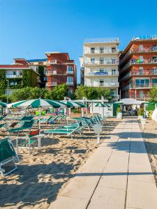 uma fila de cadeiras de praia e guarda-sóis numa praia em Strand Hotel em Gabicce Mare