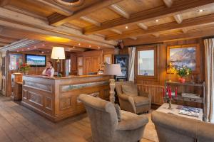 a woman standing at a bar in a room at Residence La Ginabelle - maeva Home in Chamonix-Mont-Blanc