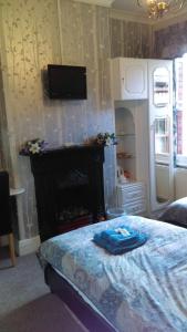 a bedroom with a bed and a tv on the wall at Hillcrest Guest House in Llangollen
