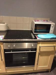 a kitchen with a stove and a toaster oven at Sea breeze holiday apartment in Weymouth