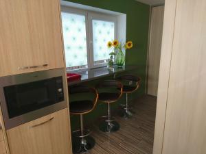 a kitchen with three bar stools and a counter at Holiday Home Noras Nams in Cēsis