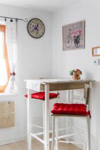 a table and stools in a kitchen with a clock on the wall at ferienwohnung lispet in Neuötting