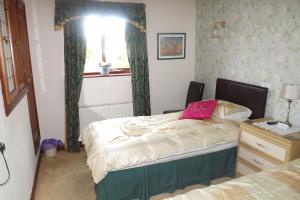 a small bedroom with a bed and a window at Hillcrest Guest House in Llangollen