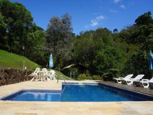 a swimming pool with two white statues next to a pool at Pousada da Mata in Cunha
