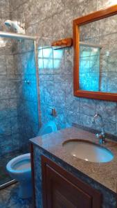 a bathroom with a sink and a toilet and a mirror at Casa Temporada em Lumiar in Lumiar