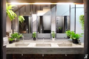 un bagno pubblico con due lavandini e due specchi di Hugger Hostel a Phuket