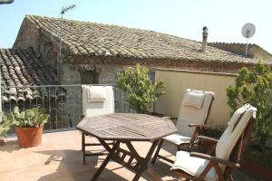a patio with two chairs and a table and a house at Apartament Ca l'Emilia in Sedo