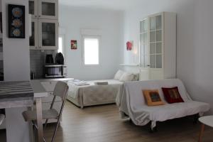 Habitación blanca con cama, mesa y silla en Ronda de Segovia, en Madrid