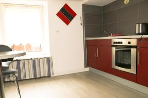 a kitchen with red cabinets and a window at Meublé Celtic in Niederbronn-les-Bains
