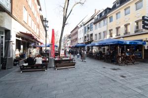 a city street with people sitting on benches and umbrellas at Altstadt Düsseldorf 1 in Düsseldorf
