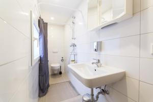 a white bathroom with a sink and a toilet at Altstadt Düsseldorf 1 in Düsseldorf +80 photos