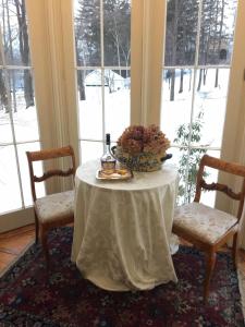 a table with a flower arrangement on it in a room with windows at Blackinton Manor in North Adams