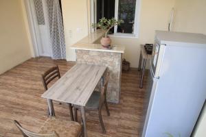 a kitchen with a wooden table and a refrigerator at Guest house Ebralidze in Mtskheta