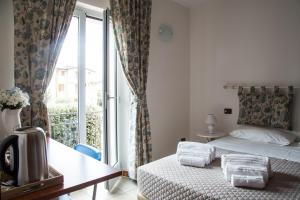 アッシジにあるLe Campane di Assisiのベッドと窓が備わるホテルルーム