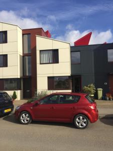 a red car parked in front of a building at Eco House in Shenley Church End