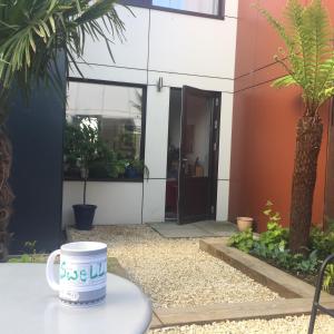 a coffee cup sitting on a table in front of a building at Eco House in Shenley Church End