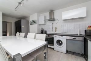 cocina con mesa blanca y lavavajillas en Altstadt Bolker Original, en Düsseldorf