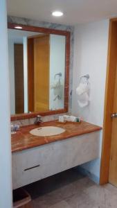 a bathroom with a sink and a large mirror at Sunset Marina Resort in Cancún