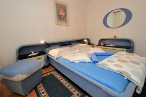 um quarto com uma cama azul e um espelho em Apartment Katica em Otočac