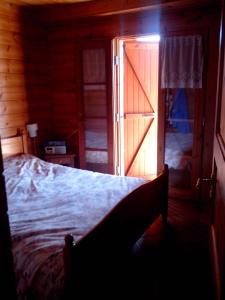 - une chambre avec un lit et une porte ouverte dans l'établissement Spacieux Chalet, à Les Chapelles