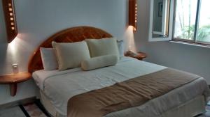 a bedroom with a large bed with white sheets and pillows at Sunset Marina Resort in Cancún
