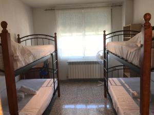 two bunk beds in a room with a window at Residencia Universitaria Atilano Coco in Salamanca