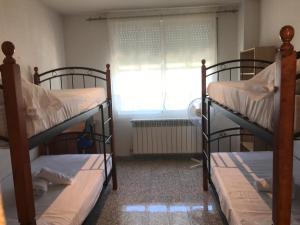 サラマンカにあるResidencia Universitaria Atilano Cocoの窓付きの客室で、二段ベッド2台が備わります。