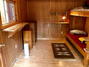 a small room with a bunk bed and a window at Sven's Basecamp Hostel in Fairbanks
