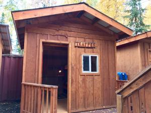 a large wooden outhouse with a transfer sign on it at Sven's Basecamp Hostel in Fairbanks