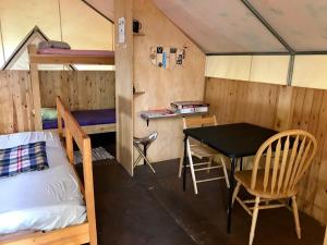 a room with a table and a bed and a desk at Sven's Basecamp Hostel in Fairbanks