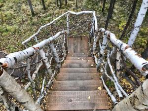 a wooden bridge with a wooden door in the forest at Sven's Basecamp Hostel in Fairbanks
