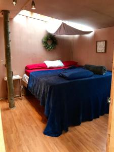a bedroom with a bed with a blue blanket at Sven's Basecamp Hostel in Fairbanks
